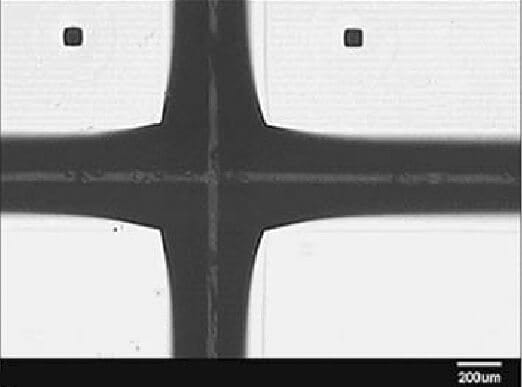 Optical picture of intersection of two channels (through glass) and holes performed by wet etching in 49% HF solution